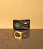 Sculptural cufflink with abstract design of a circle and globe in bronze with blue green patina